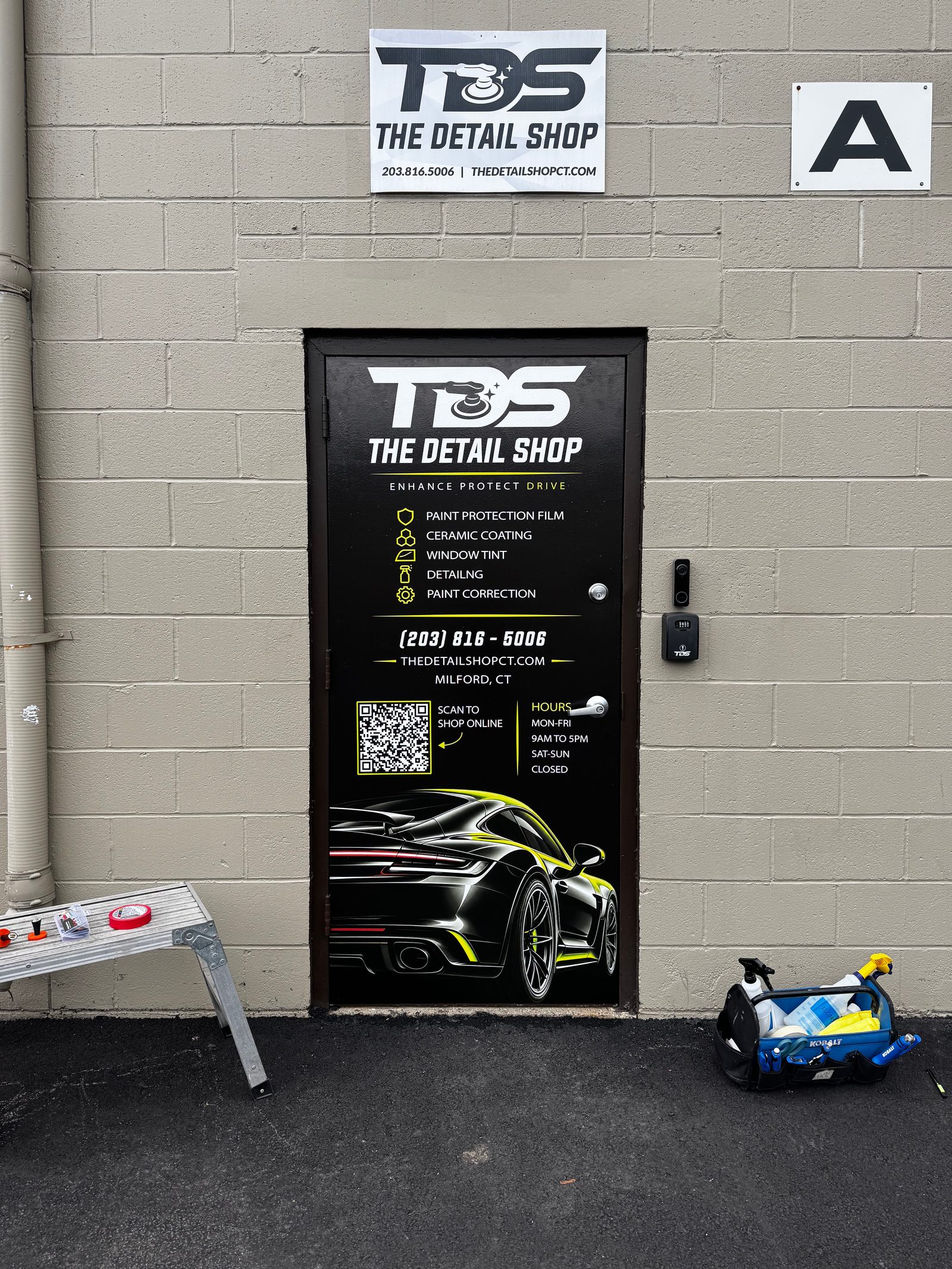 Finished custom printed door graphics at The Detail Shop in Milford, CT, with the TDS logo, service list, phone number, hours, QR code, and a black sports car graphic